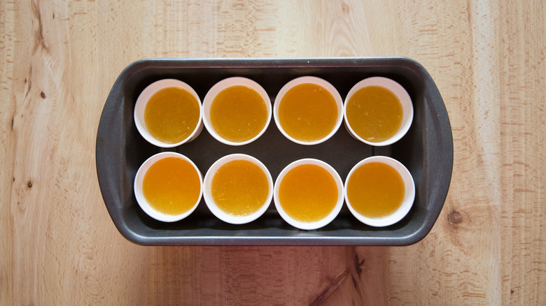 Dixie cups filled with liquid in a loaf pan