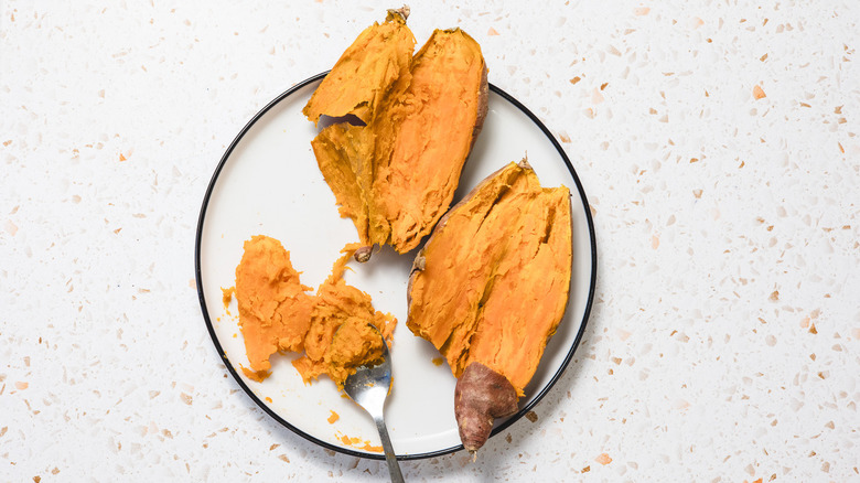 Cut sweet potato halves on plate with spoon