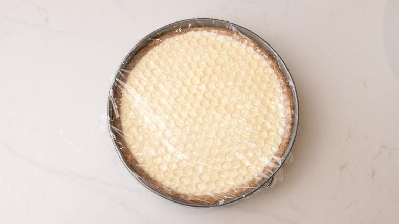 aerial view of honeycomb pie in cake pan wrapped in food wrap