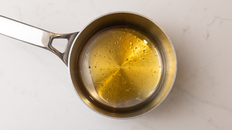 saucepan containing syrup ingredients on marble surface