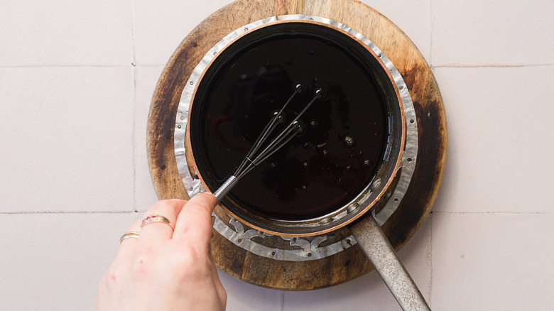 Whisking a saucepan of brown sugar syrup