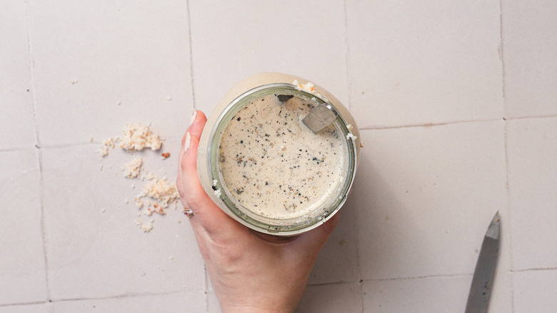 Hand holding jar with horchata and vanilla