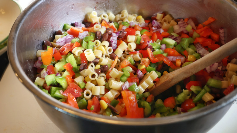 mixing bowl of ditalini pasta with beans and diced vegetables