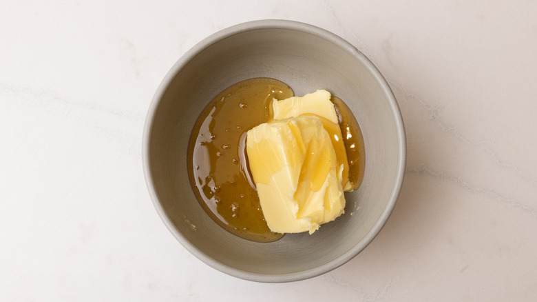aerial view of butter and honey in bowl on marble surface