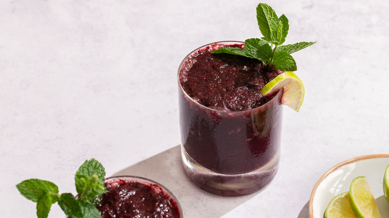frozen blueberry mojitos garnished with mint leaves and lime wedges