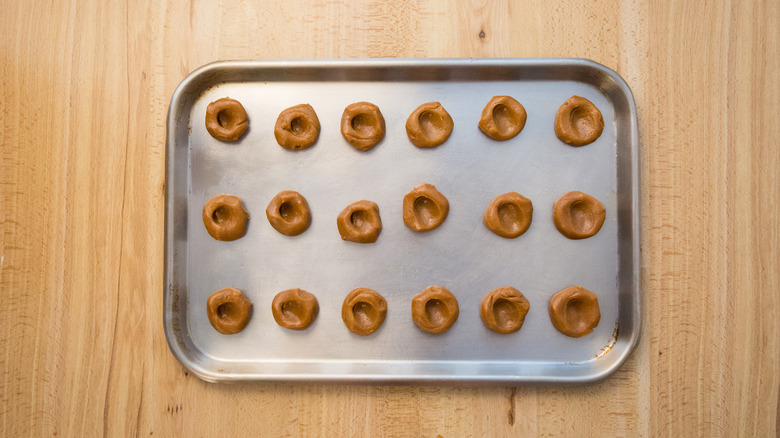 partially made thumbprint cookies on pan
