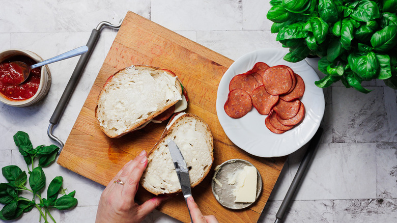 Spreading grilled cheese with butter