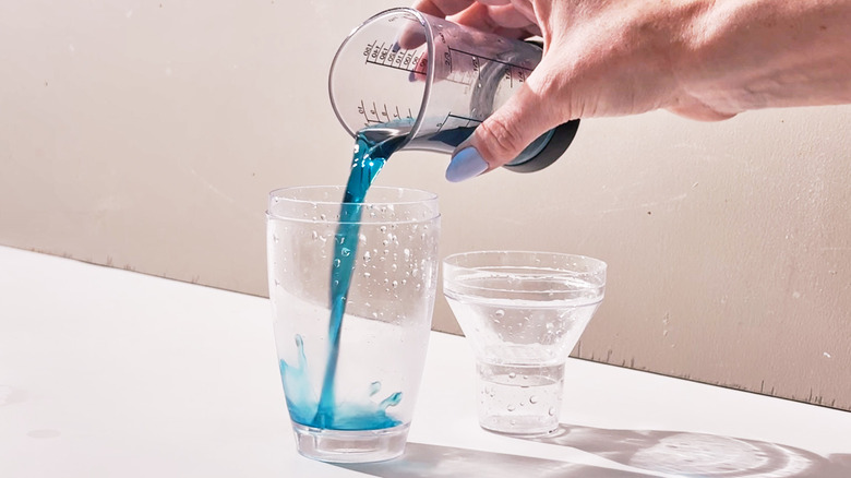 pouring blue curacao into shaker