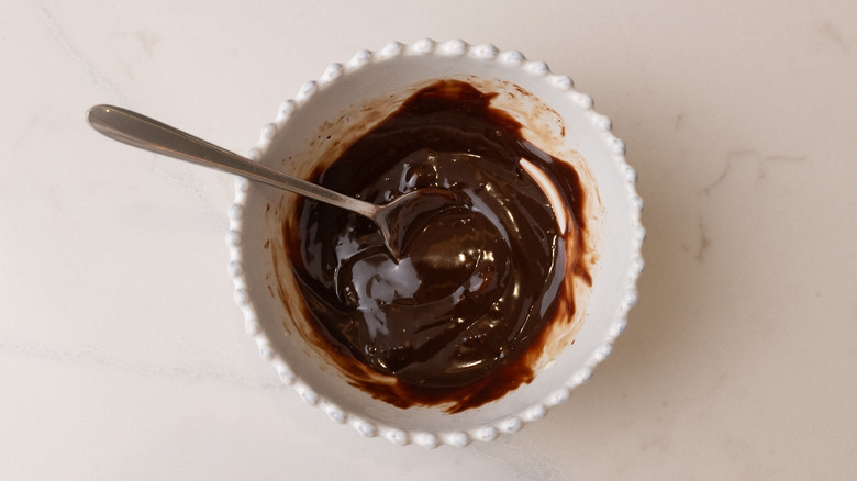 Melted chocolate in bowl with spoon