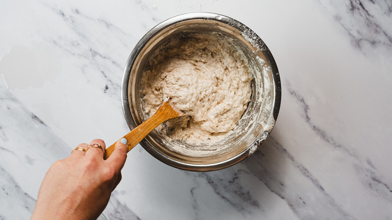 Mixing beer bread batter with wooden spoon