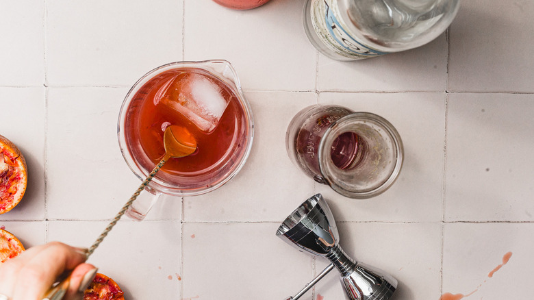 Stirring cocktail in mixing glass over ice