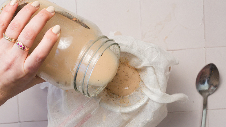 Pouring horchata through a double strainer