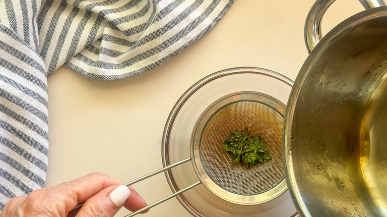 hand holding strainer with mint