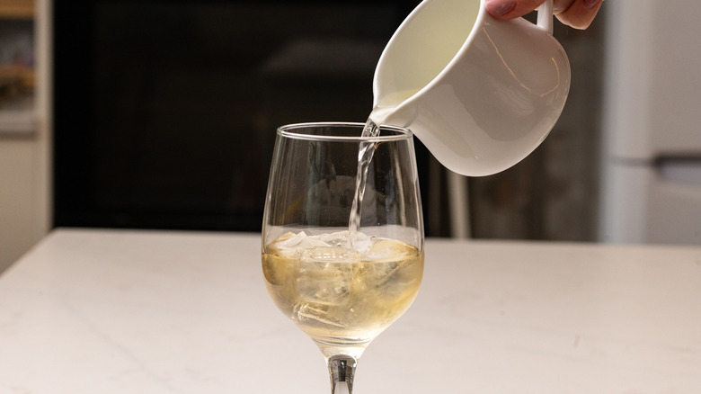 pouring white wine into glass