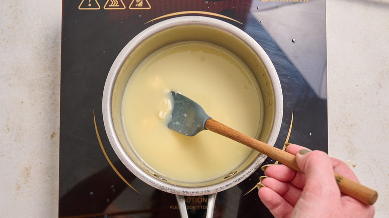 stirring melted chocolate in saucepan