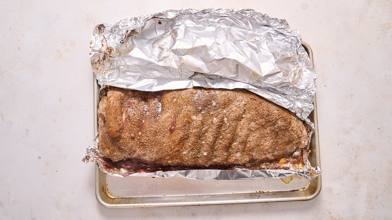 aerial view of baked ribs with foil on a baking sheet