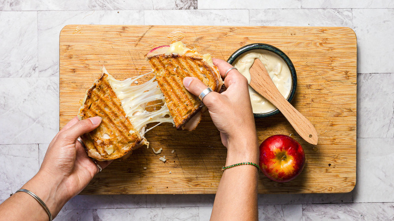 Pulling apart a grilled apple turkey cheddar sandwich