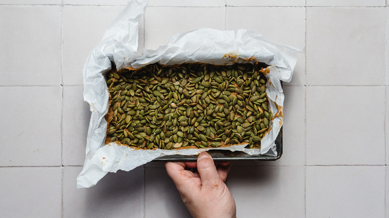 Raw pumpkin bread with pumpkin seeds on top in pan
