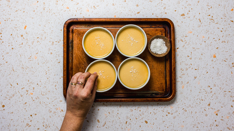 Sprinkling salt on caramel panna cotta