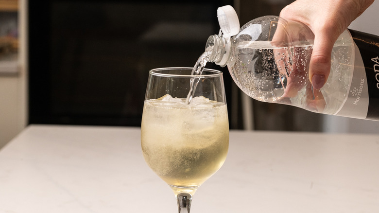 pouring soda water into glass