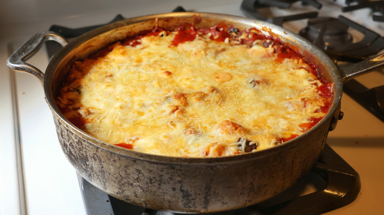 skillet of gnocchi lasagna topped with melted cheese on stovetop