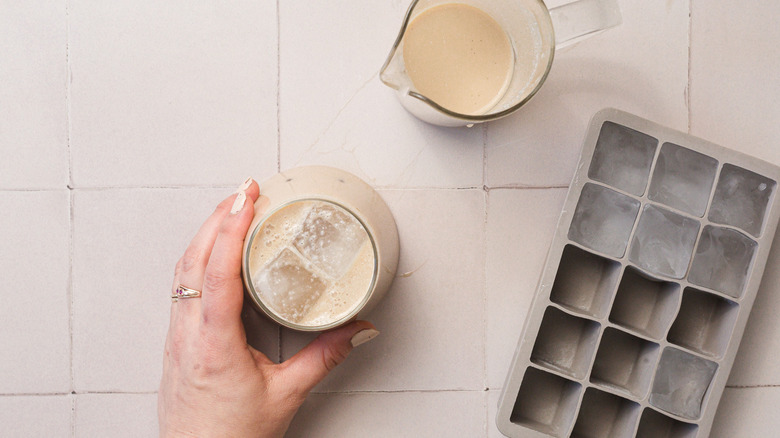 Hand holding glass of horchata with ice