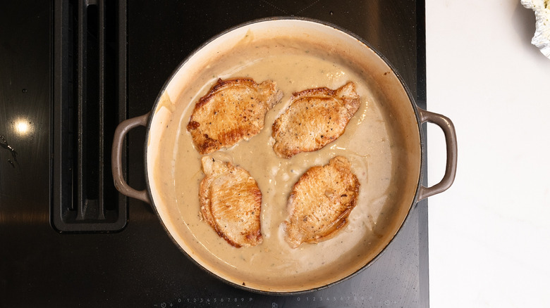 pork chops cooking in sauce