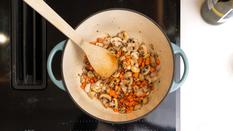 sautéing vegetables in a pan