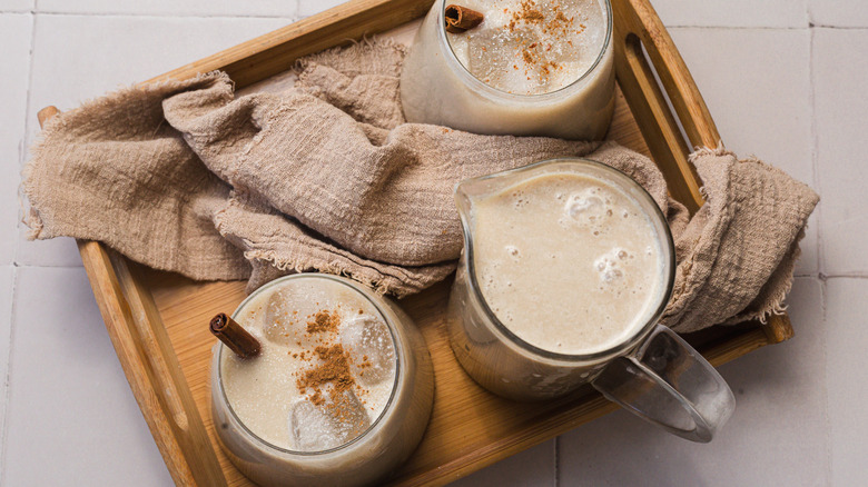 Two glasses and pitcher of horchata in tray