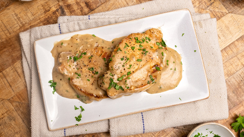 Pork chops on serving plate with sauce