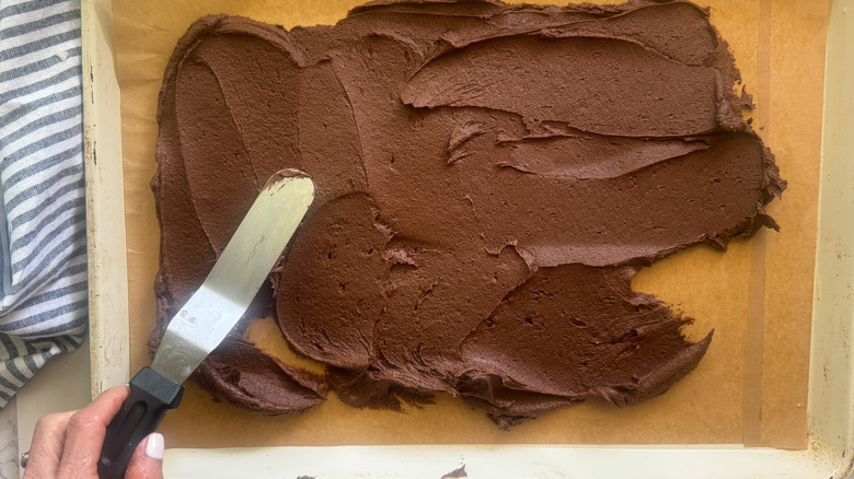 hand spreading dough in pan