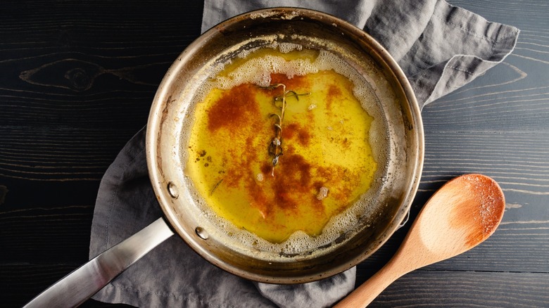 Brown butter infused with fresh rosemary in a stainless steel skillet