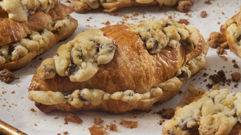 Baking sheet of croissants stuffed and topped with cookie dough