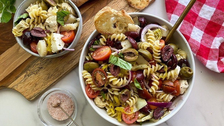Bowl of Italian-style pasta salad with olives, tomatoes, and red onions