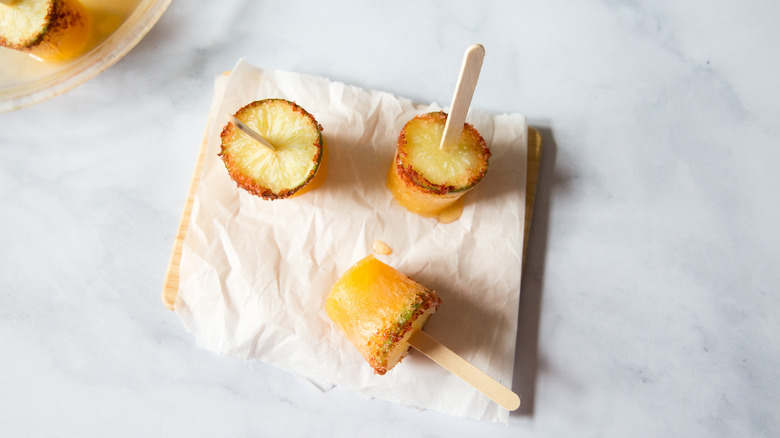 margarita popsicles arranged on lined cutting board on marble table
