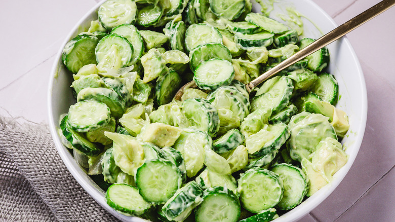 Bowl of avocado cucumber salad with spoon