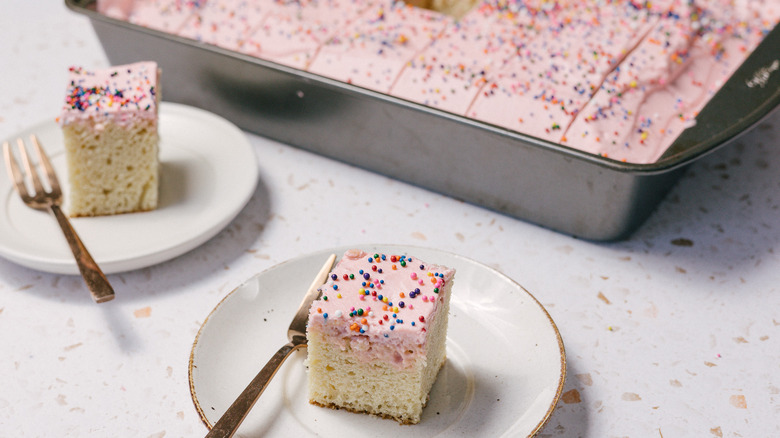 two slices of Mexican pink cake on small plates with large cake pan in background