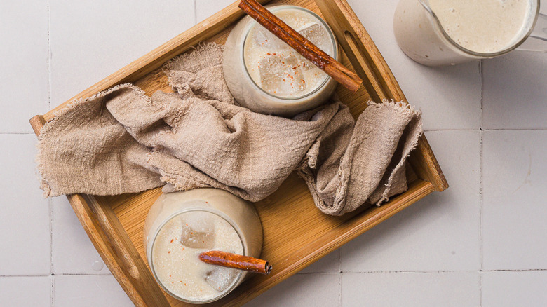 Two glasses of horchata in tray beside pitcher