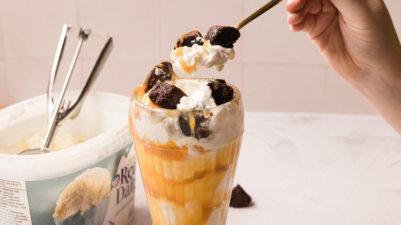 Lifting a spoonful of Costco caramel brownie sundae