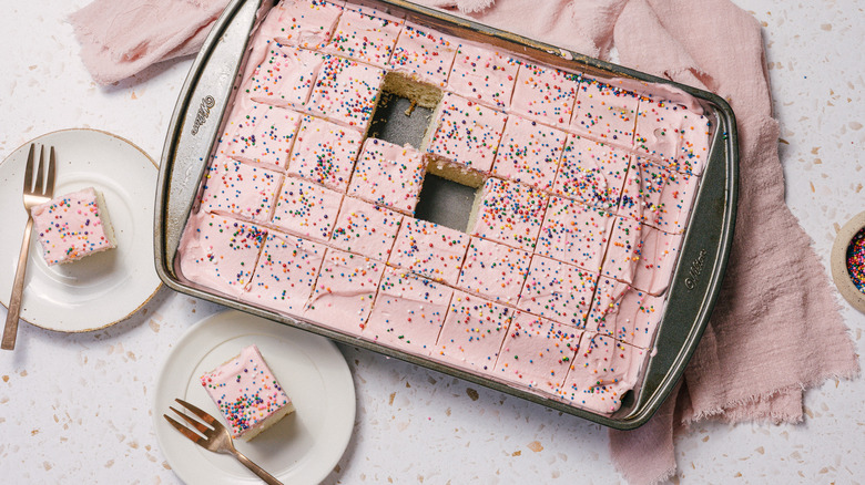 two slices of Mexican pink cake on small plates with large cake pan in background