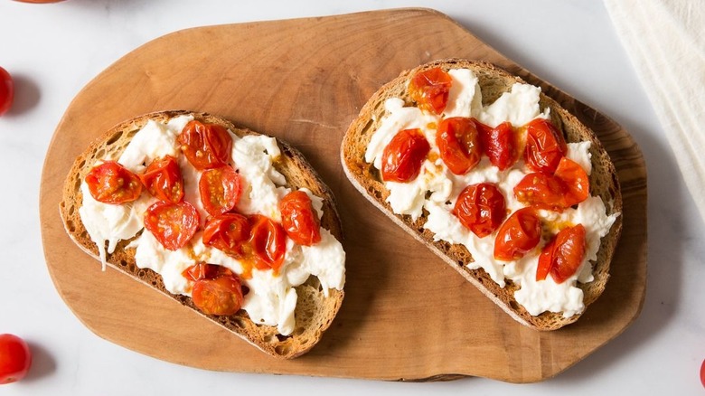 Burrata tomato toast on wooden board