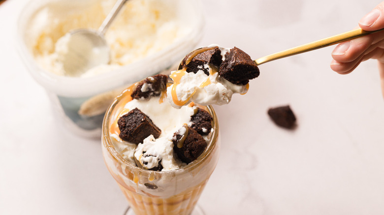 Lifting a spoonful of Costco caramel brownie sundae